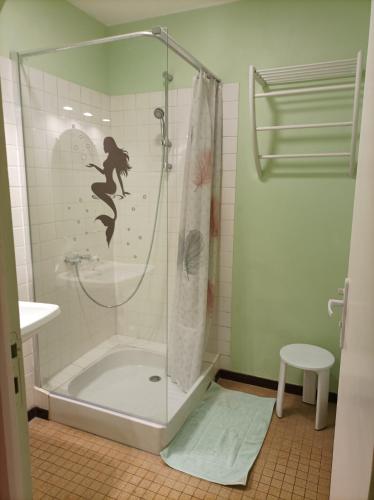 une salle de bain avec une douche avec une sirène sur le mur dans l'établissement L'annexe, à Chalindrey