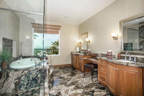 拉斯維加斯的住宿－南拉斯維加斯希爾頓惠庭套房酒店，浴室配有2个盥洗盆、浴缸和淋浴。