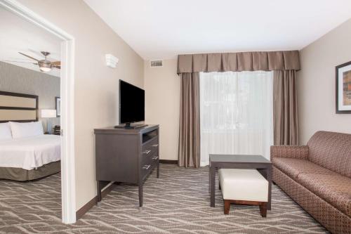 a hotel room with a couch and a bed at Homewood Suites by Hilton South Las Vegas in Las Vegas