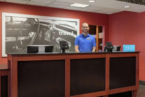a man standing behind a counter in a office at Hampton Inn & Suites Lawton in Lawton