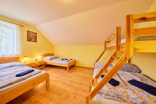 - une chambre avec deux lits superposés et un lit dans l'établissement Apartmány Eva, à Janské Lázně