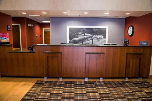 a lobby with a bar with a clock on the wall at Hampton Inn Lewisburg in Lewisburg