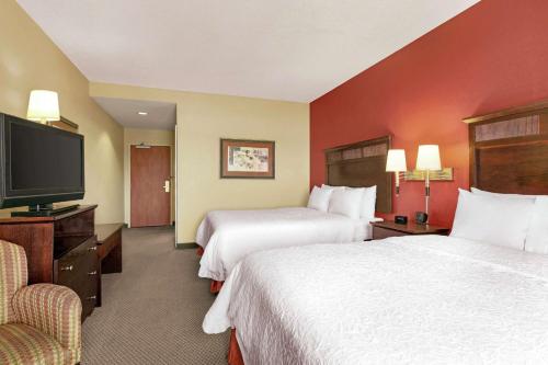 a hotel room with two beds and a flat screen tv at Hampton Inn & Suites Lawton in Lawton