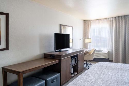 a hotel room with a desk with a flat screen tv at Hampton Inn by Hilton Irvine East - Lake Forest in Foothill Ranch