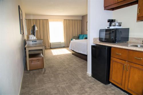 a hotel room with a bed and a kitchen with a microwave at Hampton Inn Lewisburg in Lewisburg