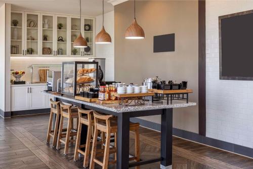 a kitchen with a counter with bar stools at Hilton Garden Inn Los Angeles/Redondo Beach in Redondo Beach