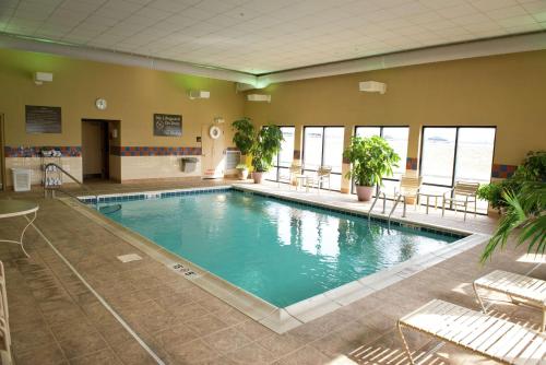 a large pool in a building with chairs and tables at Hampton Inn Lebanon in Lebanon