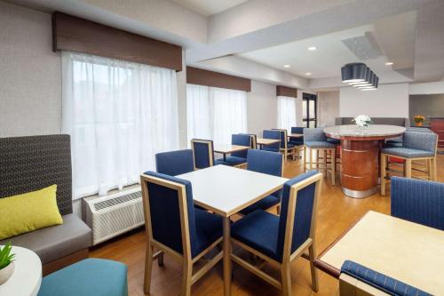 una sala de espera con mesas y sillas y un bar en Hampton Inn Lexington South, en Lexington
