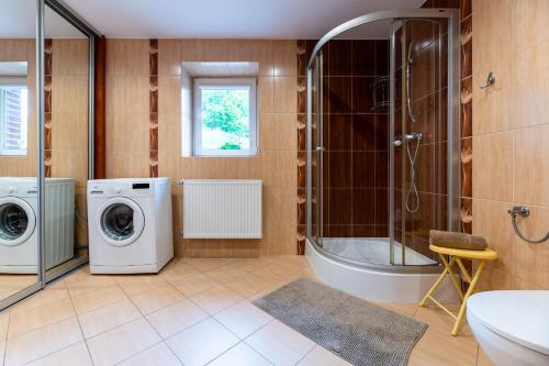 a bathroom with a washing machine and a shower at Willa Malinówka - ogród wypoczynkowy z widokiem na Śnieżkę in Karpacz
