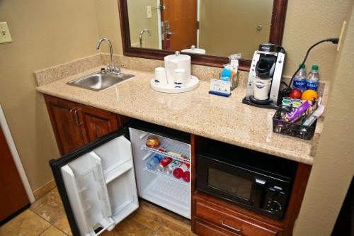 a kitchen counter with a sink and a refrigerator at Hampton Inn & Suites Jennings in Jennings
