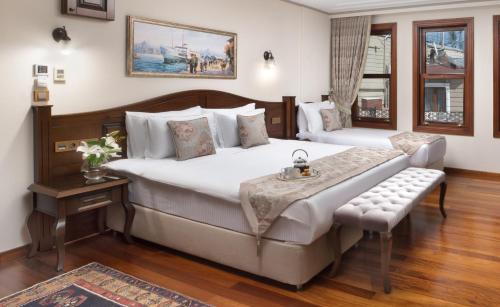 a bedroom with a large bed and a bench in it at Bender Hotel in Istanbul