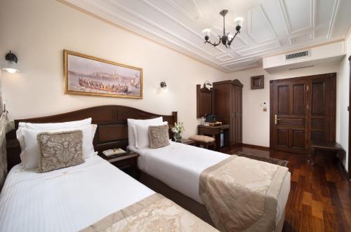 a hotel room with two beds and a table at Bender Hotel in Istanbul