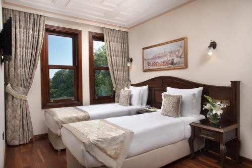 a hotel room with two beds and a window at Bender Hotel in Istanbul