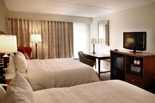 ein Hotelzimmer mit 2 Betten und einem Flachbild-TV in der Unterkunft Hampton Inn Lima in Lima