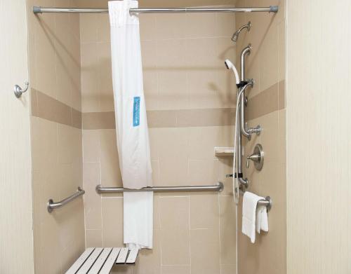 a bathroom with a shower with a toilet and towels at Hampton Inn & Suites Bay City in Bay City
