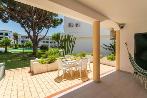 a patio with a table and chairs on it at Host Wise - Amazing Sunny Flat - Swimming Pool & Terrace in Vilamoura