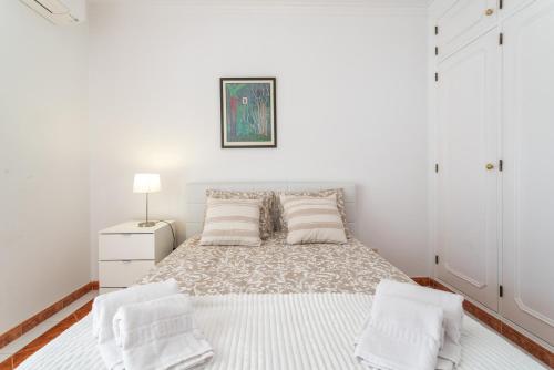 a white bedroom with a bed with two pillows at Host Wise - Amazing Sunny Flat - Swimming Pool & Terrace in Vilamoura