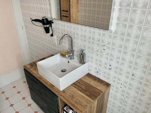 une salle de bain avec un lavabo blanc et un miroir dans l'établissement Maison avec Terrasse Surplombant la Vallée, à Sarlat-la-Canéda
