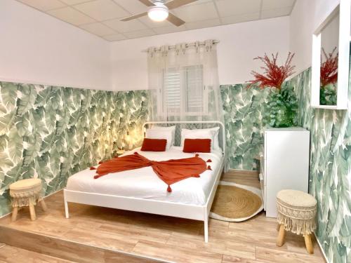 Un dormitorio con una cama blanca con almohadas rojas. en CASA SOLE - Apartamento Playa San Juan, en Guía de Isora
