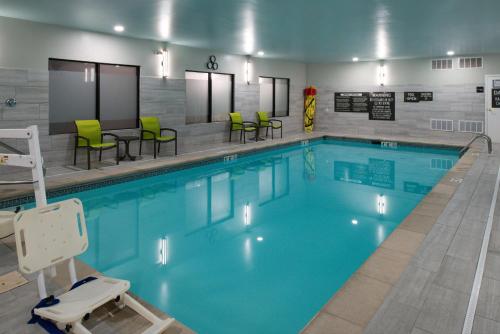 a large swimming pool with green chairs and tables at Hampton Inn LaPorte in LaPorte