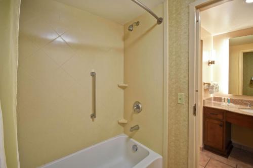 a bathroom with a white tub and a sink at Homewood Suites by Hilton Lancaster in Lancaster