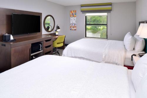 a hotel room with two beds and a flat screen tv at Hampton Inn LaPorte in LaPorte