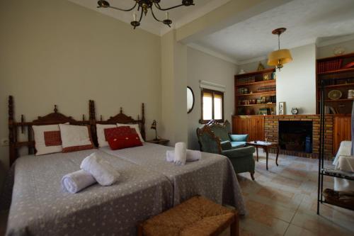 a bedroom with a large bed and a living room at tuGuest Hortichuela House in Ugíjar