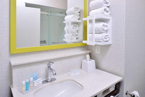 a bathroom with a sink and a mirror and towels at Hampton Inn LaPorte in LaPorte