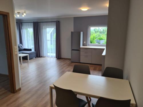a kitchen and dining room with a table and chairs at Apartamenty Myśliwska 115 in Gdańsk