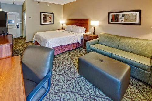 a hotel room with a bed and a couch at Hampton Inn Laurinburg in Laurinburg