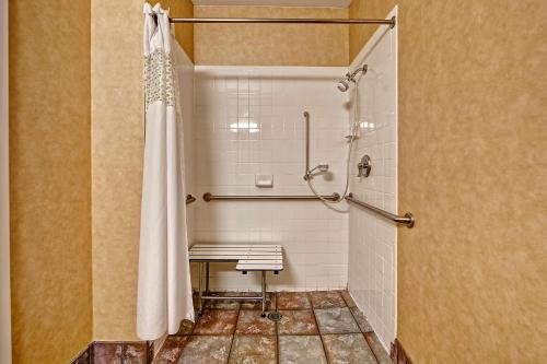 y baño con ducha y banco. en Hampton Inn Laurinburg, en Laurinburg