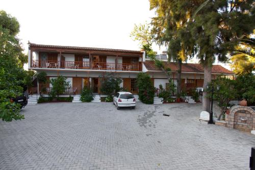 un coche aparcado en un aparcamiento frente a un edificio en Villa Christina en Tolo