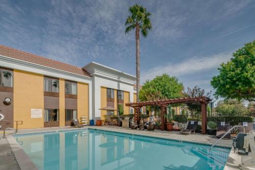 a swimming pool in front of a hotel with a palm tree at Hampton Inn Livermore in Livermore