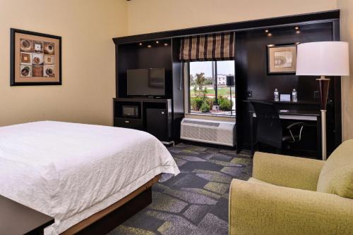 una camera d'albergo con un letto, una sedia e una finestra di Hampton Inn & Suites Big Spring a Big Spring