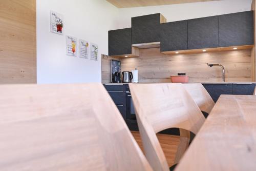 a kitchen with wooden counters and wooden tables at AuszeitHof Vögel in Sulzberg