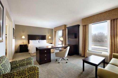 a hotel room with a bed and a desk and chairs at Hampton Inn & Suites Mahwah in Mahwah