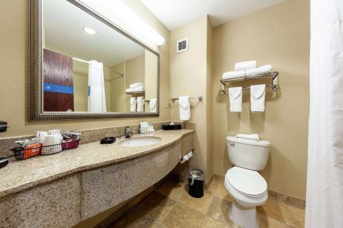a bathroom with a toilet and a sink and a mirror at Hampton Inn Inwood in Inwood