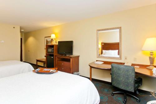 a hotel room with a desk and a bed and a desk at Hampton Inn Inwood in Inwood