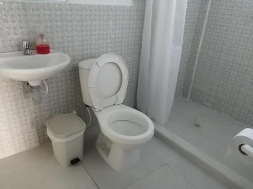 a white bathroom with a toilet and a sink at CASA TORO in Puerto Triunfo
