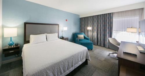 um quarto de hotel com uma cama, uma secretária e uma cadeira em Hampton Inn Lakeland em Lakeland
