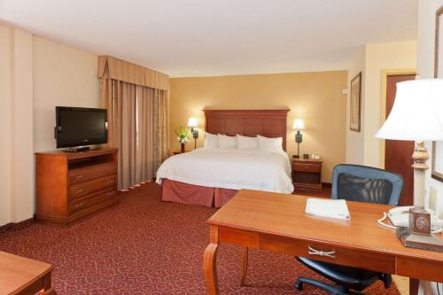 una camera d'albergo con letto e scrivania di Hampton Inn & Suites McComb a McComb