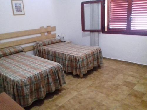 a hotel room with two beds and a window at Casa Mercedes in San Ferrán de ses Roques