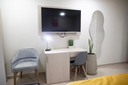 a room with a desk with a tv and a chair at BLISS BOUTIQUE HOTEL BOGOTA in Bogotá