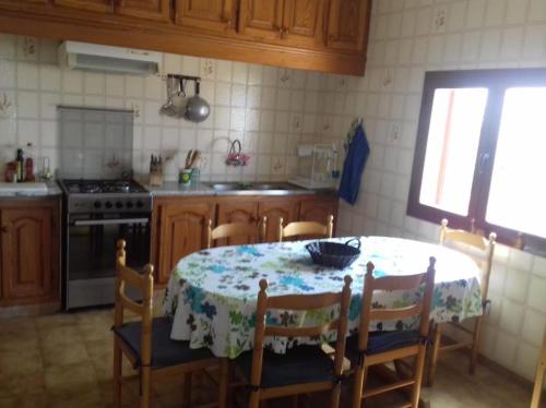 a kitchen with a table and chairs with a table and a table and a kitchen at Casa Mercedes in San Ferrán de ses Roques