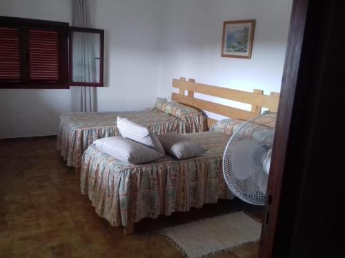a room with two beds and a bench with pillows at Casa Mercedes in San Ferrán de ses Roques