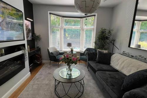 a living room with a couch and a table at Stylish home close to Arena in Wincobank