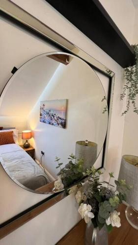 a mirror on the wall of a room with a bed at Stylish home close to Arena in Wincobank