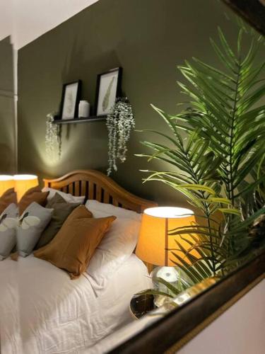 a bedroom with a bed with two lamps and a plant at Stylish home close to Arena in Wincobank