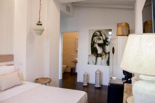 a bedroom with a bed and a picture of a woman at Amelia Apts & Rooms in Alghero