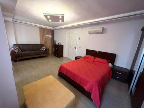 1 dormitorio con cama roja y sofá en Villa ateş en Belek